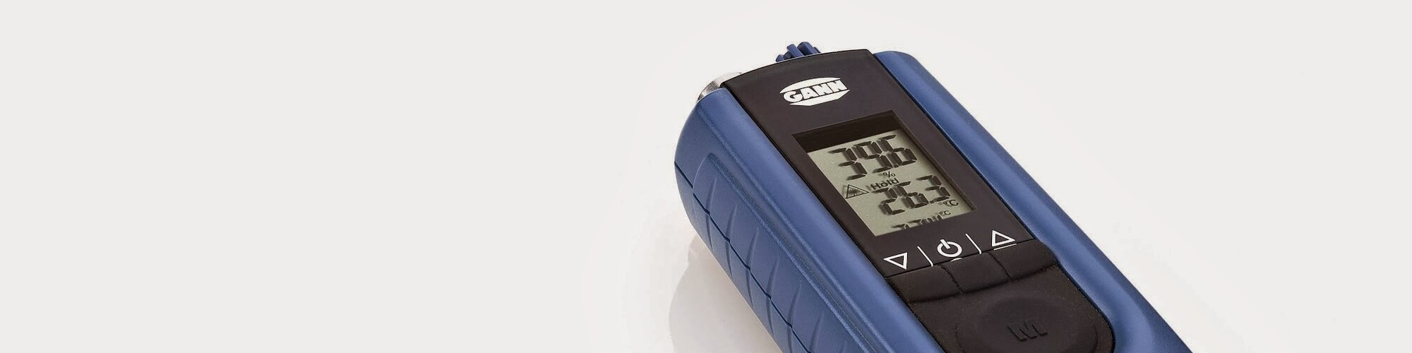 Hintergrundbild zeigt eine schräg liegendes Feuchtigkeitsmessgerät. Auf dem Display sind Messwerte abgebildet.